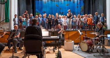 Kinder der musikalischen Grundfächer auf der Bühne, Lehrerorchester  im Vordergrund